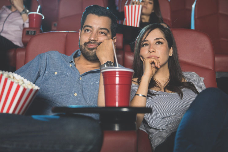 couple at a movie theatre eating popcorn