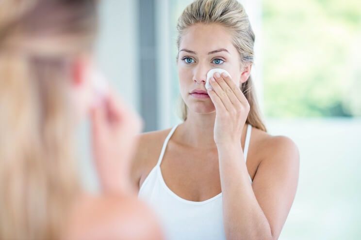 woman applying to face with cotton