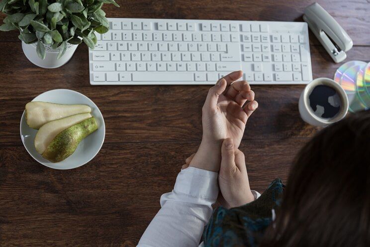 woman at desk with Rheumatoid arthritis