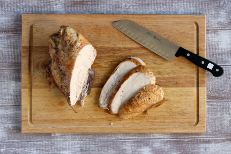 roasted turkey breast sliced on a chopping board