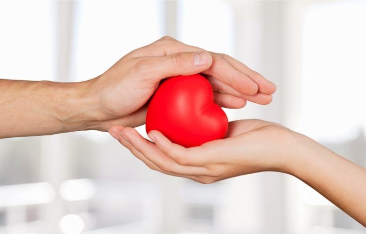 couple cupping a heart with their hands