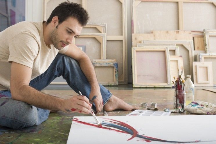 man painting on canvas