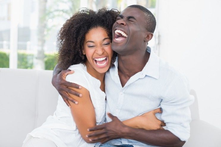 young couple laughing on the couch