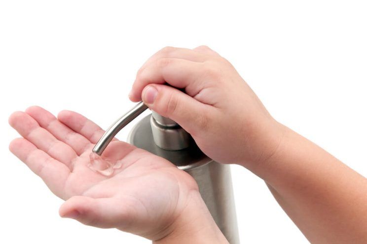 Kid pouring alcohol-based sanitizer