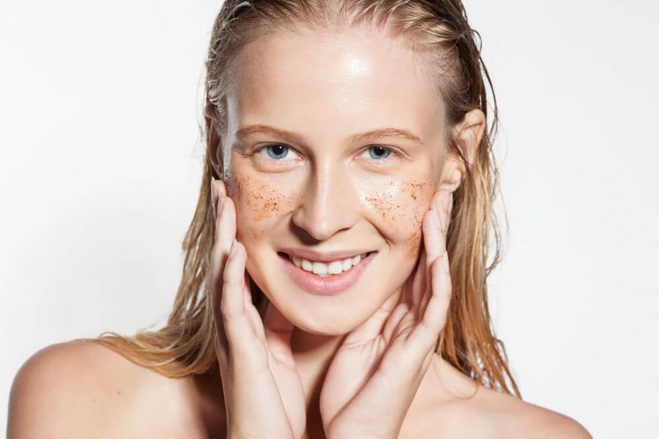 Smiling woman cleans the skin coffee scrub