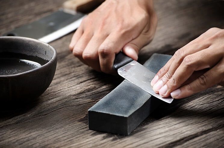 person sharpening knife