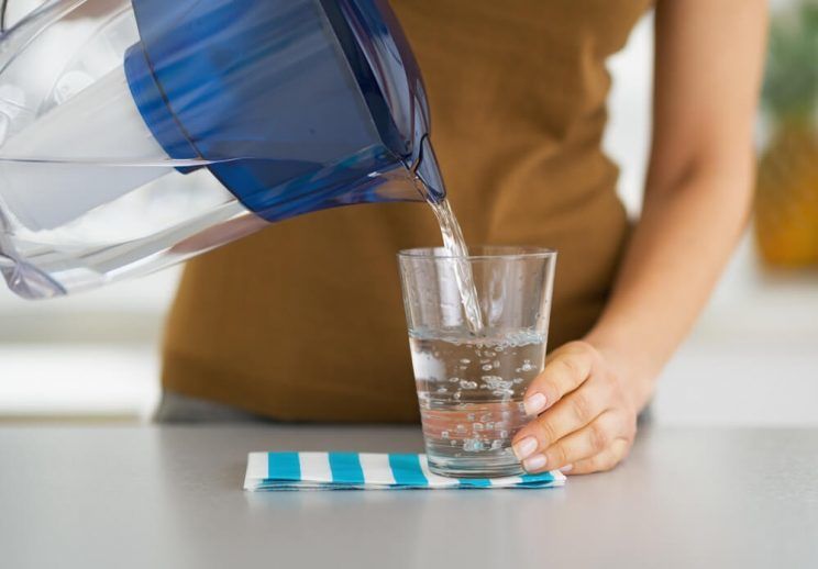 pouring water into a glass from filter