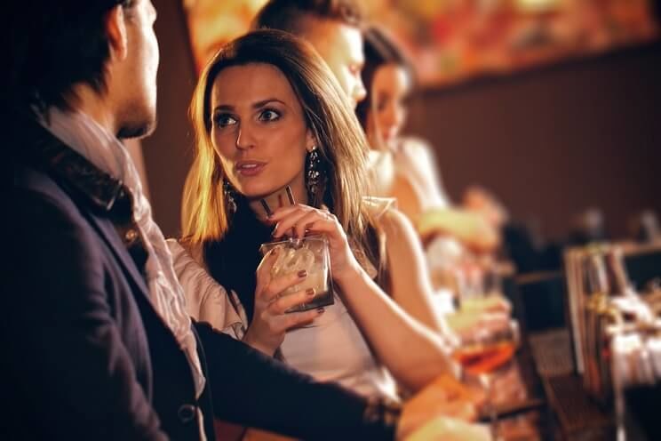 woman talking to a man at a bar