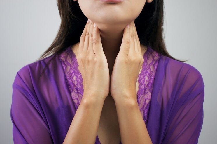 woman holding thyroid