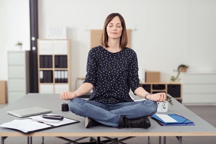 woman meditating on desk