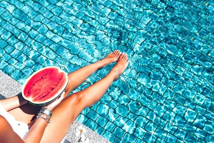 woman poolside with watermelon