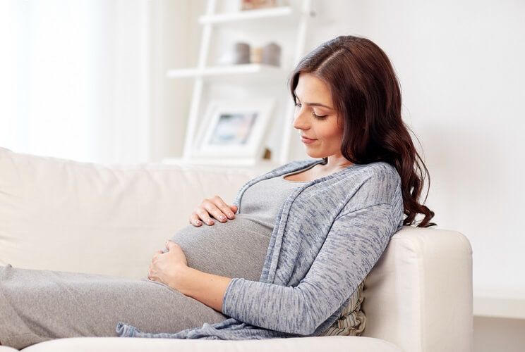 pregnant woman reclining on couch