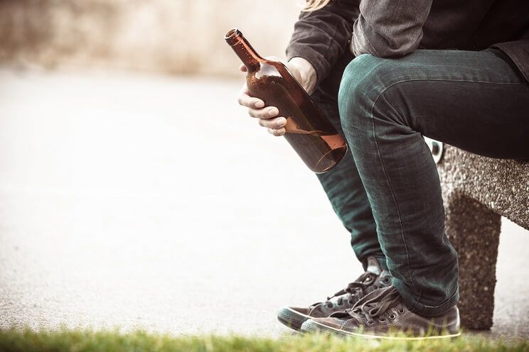 depressed man drinking outside