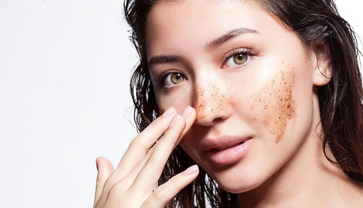 woman exfoliating with coffee grounds