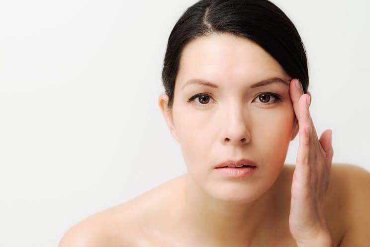 woman looking at eye circles