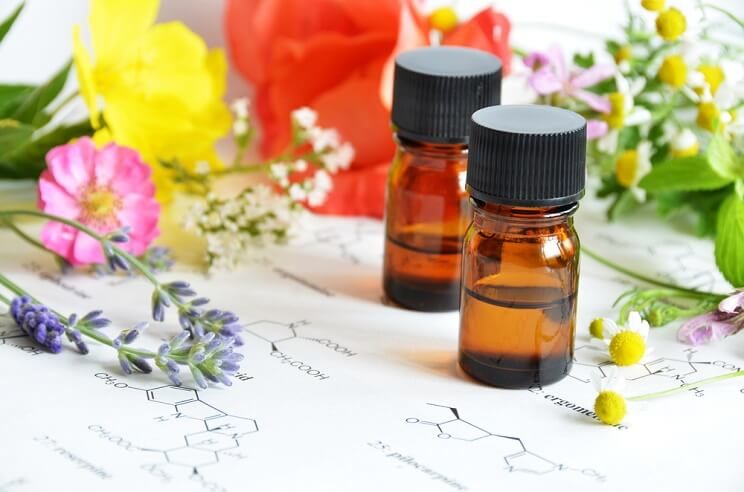 bottles of geranium oil with flowers