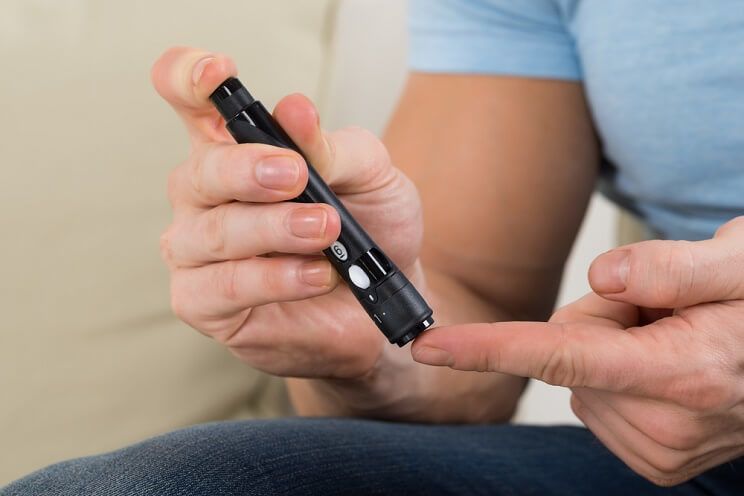 man checking blood sugar