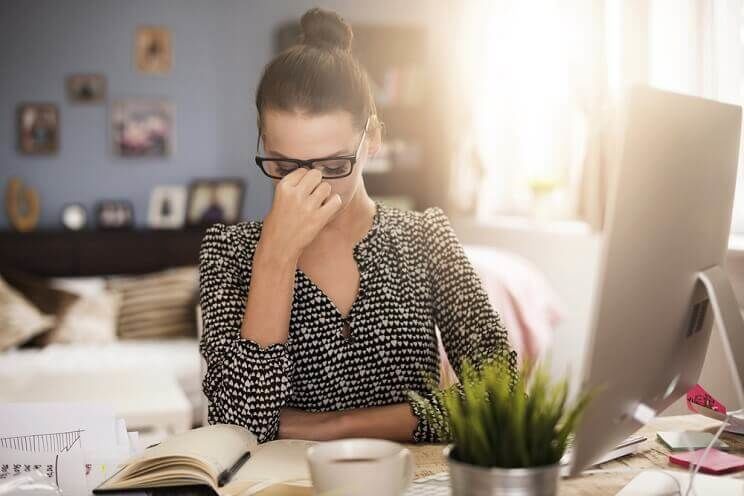 woman with a headache at her desk