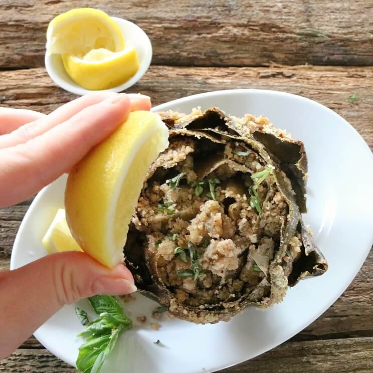 lemon squeezed onto baked stuffed artichokes