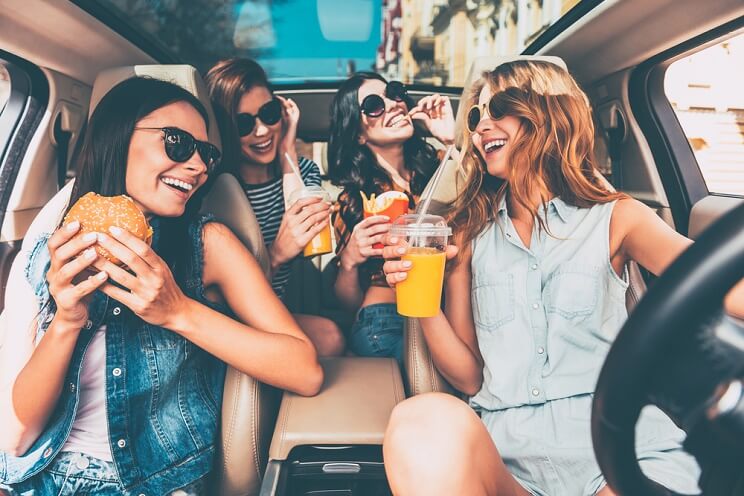 women snacking in a car together