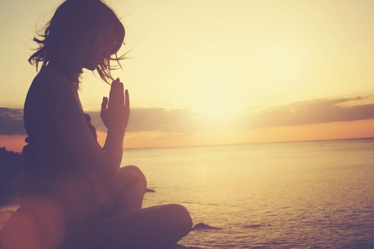 woman doing yoga on the beach