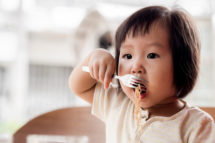 baby eating noodles