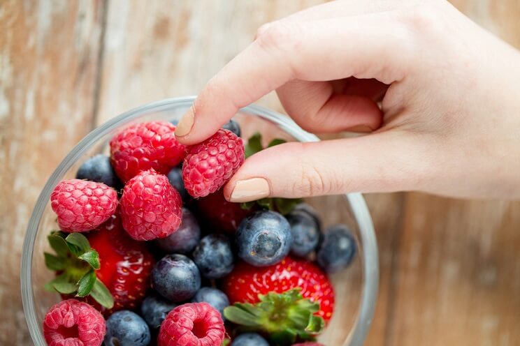 fingers picking up a berry