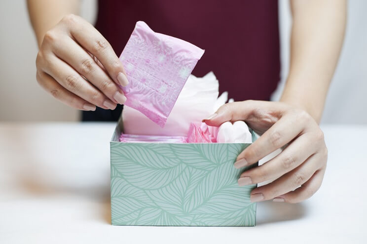 woman choosing feminine product from a box