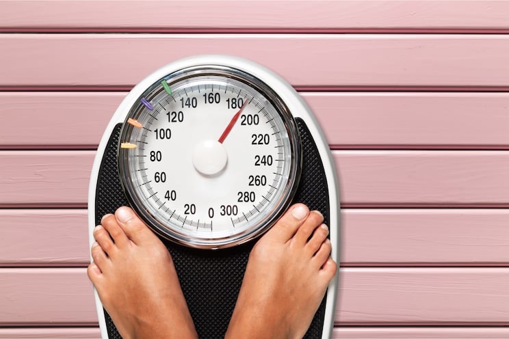 woman stepping on a weight scale