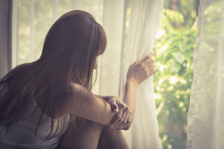 sad girl looking out window