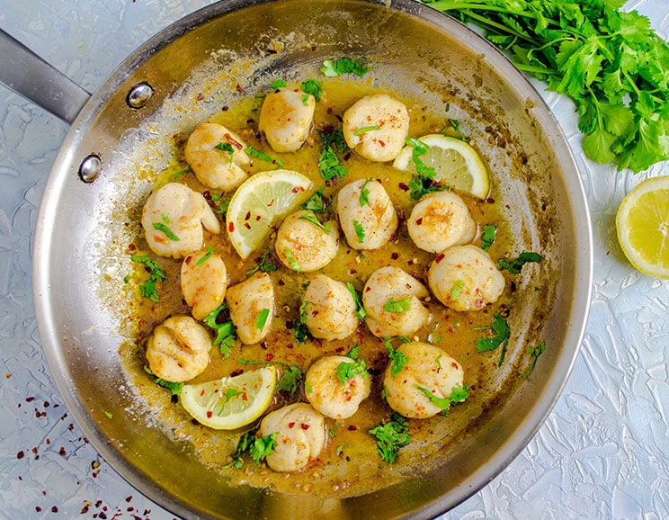 Seared scallops with herb-infused lemon butter sauce will melt in your mouth. All you need is ten minutes and a handful of ingredients.