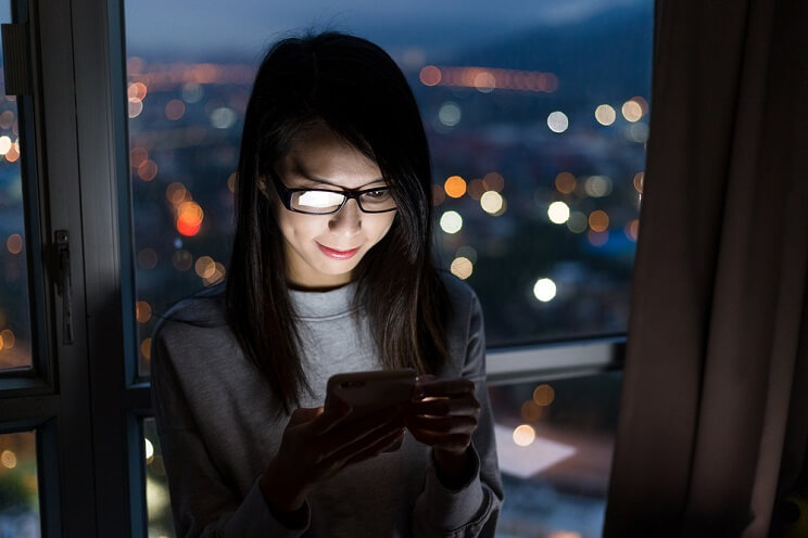 woman looking at phone at night