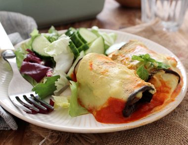 Roasted eggplant slices get wrapped around a mushroom filling, covered with a creamy tomato sauce and drenched in cashew cheese for enchiladas.