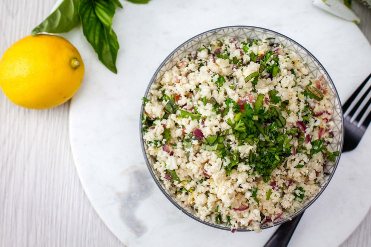 Zest up your dinner menu with this grain-free Lemon and Herb Cauliflower Rice. Grains don't stand a chance with this one.