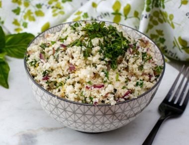 Zest up your dinner menu with this grain-free Lemon and Herb Cauliflower Rice. Grains don't stand a chance with this one.
