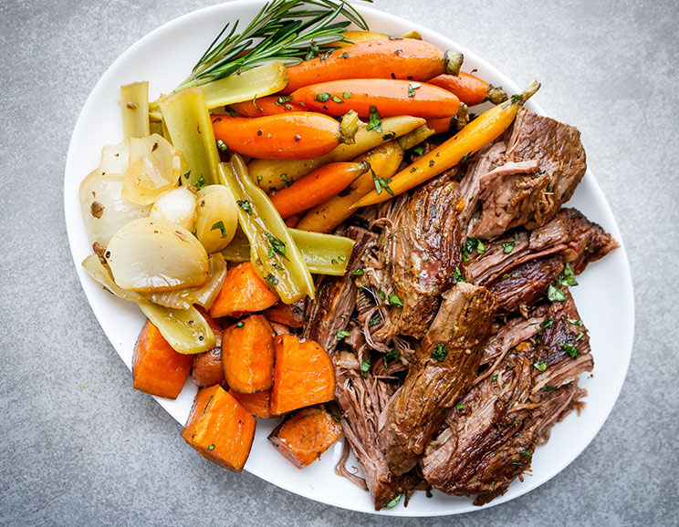Slow cook tender chunks of beef into a wholesome meal with savory veggies, broth, and fresh herbs. Cozy up with this hearty beef and veggie roast!