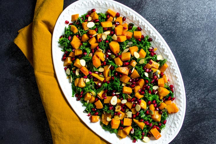 Tender kale greens get tossed with caramelized butternut squash for a hearty salad filled with nourishing ingredients.