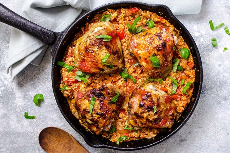 Jazz up your basic one-pan dinner with this crispy skin chicken over tomato-infused cauliflower rice.