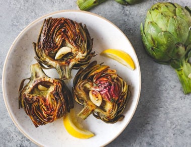 Easily roast up artichokes with melted ghee, lemon, and fresh herbs for a savory 6-ingredient appetizer!