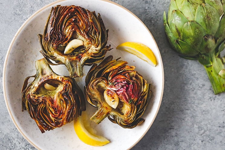 Easily roast up artichokes with melted ghee, lemon, and fresh herbs for a savory 6-ingredient appetizer!