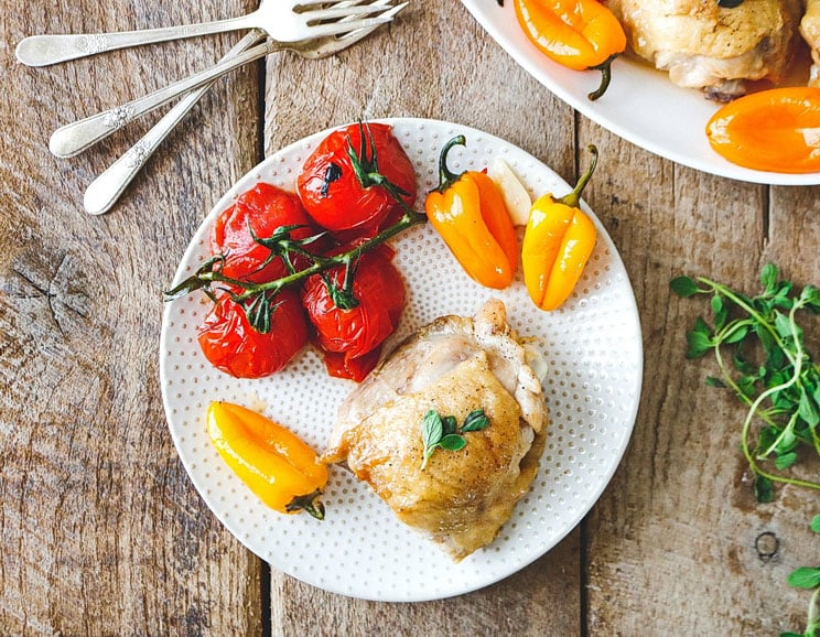 Simmer these Dutch oven chicken thighs with tomatoes and peppers for an easy meal with practically zero prep. The dutch oven makes all the difference.