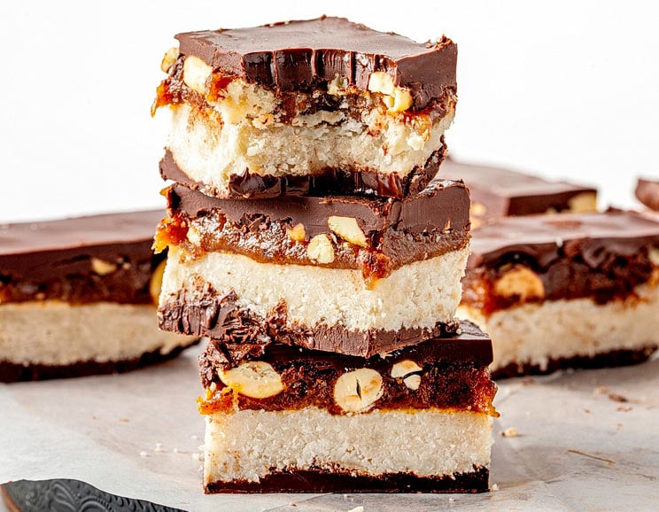 Craving candy? You’ll love this simple Paleo Snickers Bar, made with coconut butter, date caramel, crunchy chopped nuts, and delicious dark chocolate.