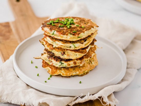 Start your morning with savory zucchini pancakes filled with bites of crunchy bacon and fresh chives! They're packed with protein, fiber and healthy fat.