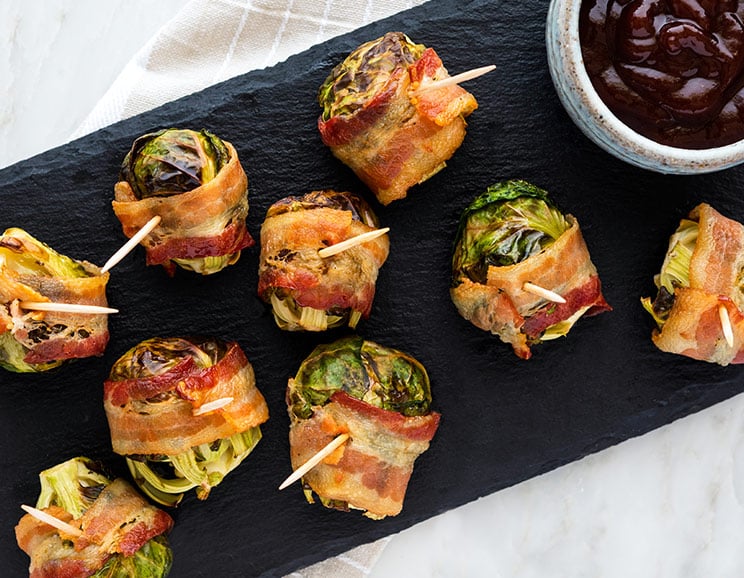 Getting ready to host a holiday party? Then you'll love this bacon-wrapped Brussel sprouts recipe. It's perfect for Paleo party trays or as a savory appetizer before dinner.