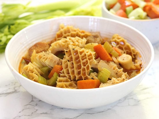 Honeycomb tripe simmers in a rich ghee and tomato sauce with veggies and crisp bacon for a protein-rich dish full of hearty flavor.